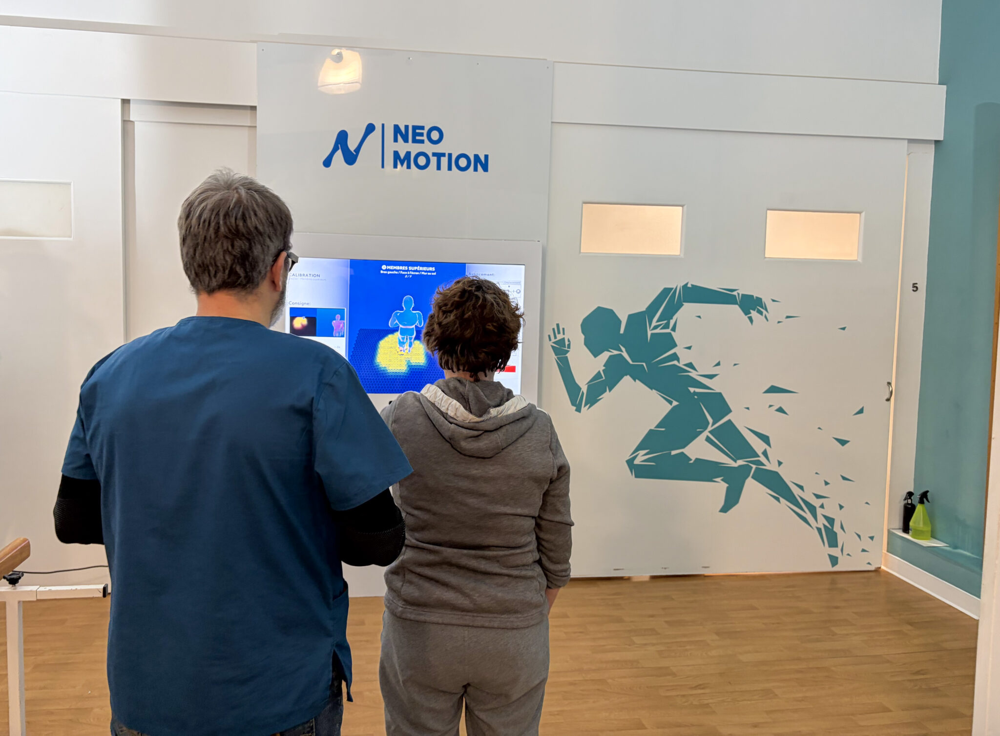 Professionnel de santé réalisant un bilan de mouvement avec une femme âgée à l’aide du coach visuel Neo-Motion