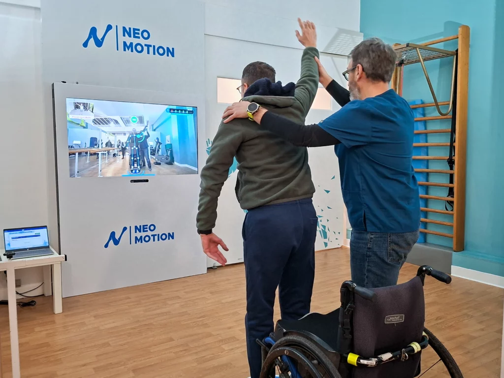Coach accompagnant une personne tétraplégique lors d’un exercice de levée de bras avec le support visuel Neo-Motion
