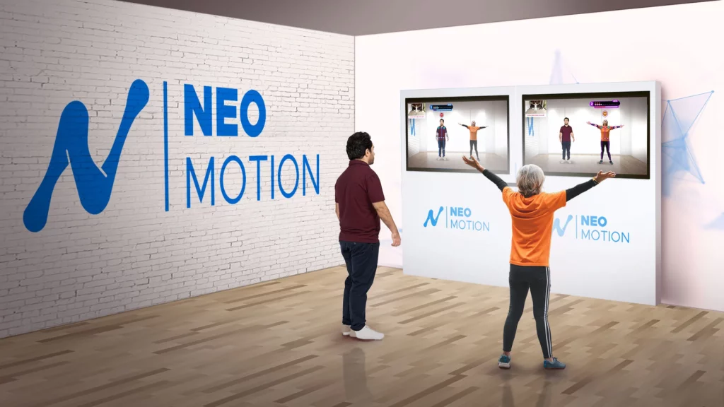 Système Neo-Motion montrant la configuration avec deux télévisions et un totem, utilisé par deux joueurs pour des exercices interactifs